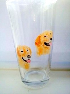 Two golden retriever glass paintings on a pint glass