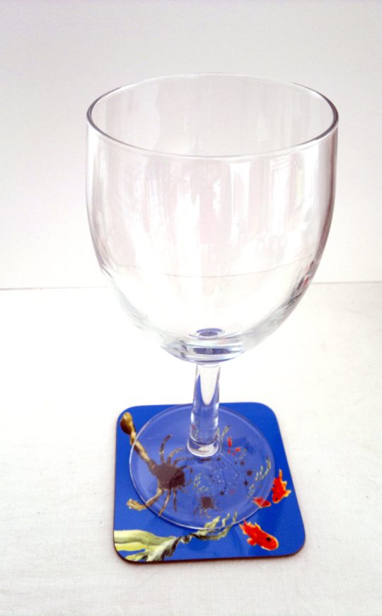 Crab coaster in an abstract style photographed with a wine glass