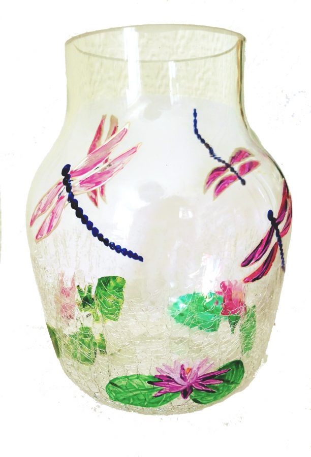 Vase with waterlilies and pink dragonfly flying overhead.